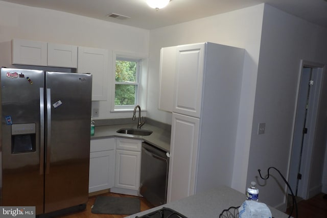 kitchen featuring dark hardwood / wood-style flooring, stainless steel appliances, white cabinets, and sink