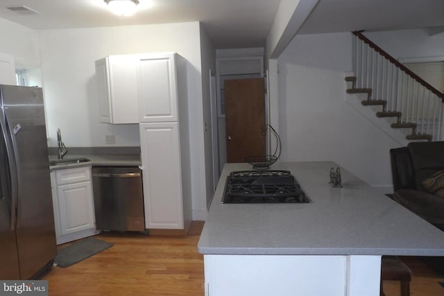 kitchen featuring white cabinets, appliances with stainless steel finishes, and light wood-type flooring