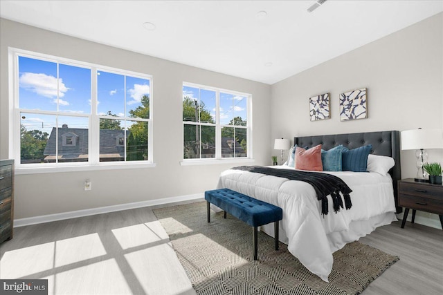 bedroom with light hardwood / wood-style flooring and multiple windows