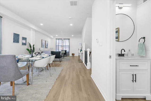 dining room featuring sink and light wood-type flooring