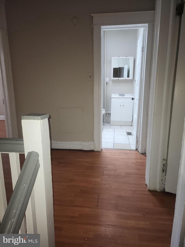 corridor with hardwood / wood-style flooring