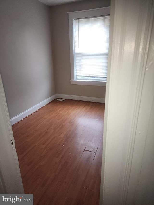 empty room with hardwood / wood-style flooring