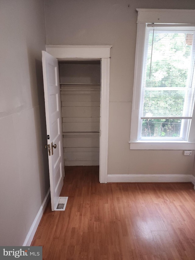 unfurnished bedroom featuring light hardwood / wood-style flooring and a closet