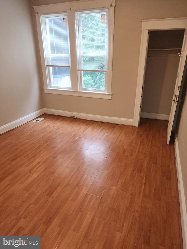 unfurnished bedroom with a closet and light hardwood / wood-style floors