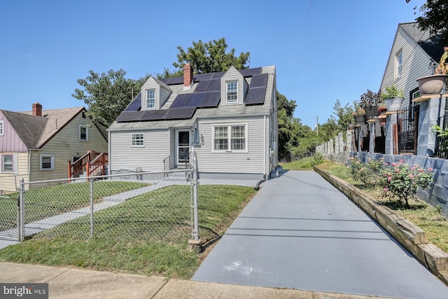 cape cod house featuring a front lawn and solar panels