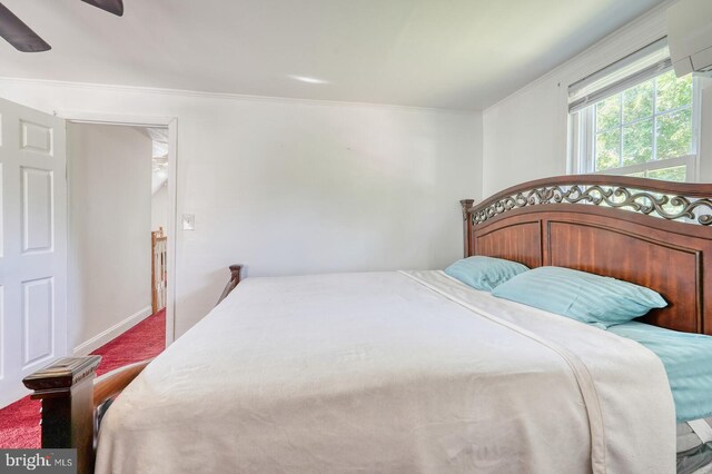 bedroom with carpet flooring, crown molding, a wall mounted air conditioner, and ceiling fan