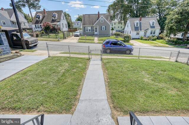 rear view of house with ac unit and a lawn