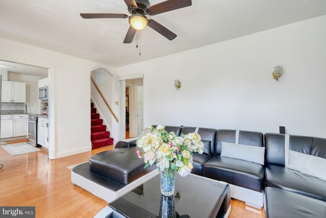 living room featuring ceiling fan and light hardwood / wood-style floors