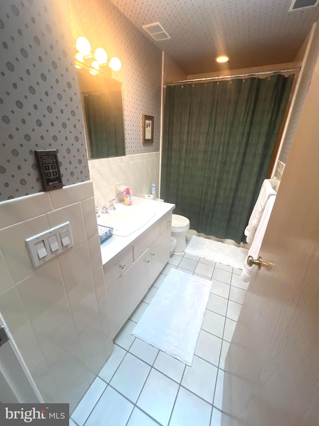 bathroom featuring tile patterned flooring, a shower with curtain, vanity, and toilet