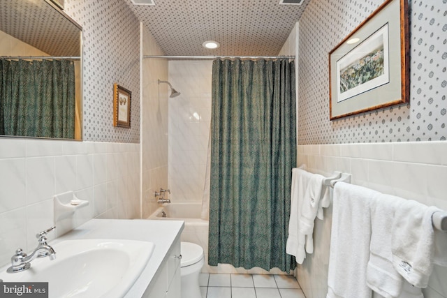 full bathroom featuring tile walls, shower / bathtub combination with curtain, vanity, tile patterned flooring, and toilet