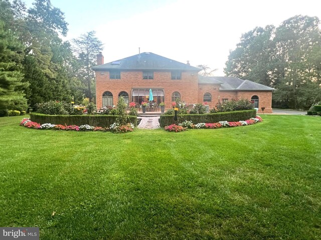 view of front facade featuring a front yard and a balcony