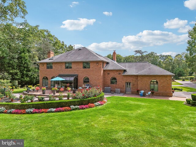 back of house with a lawn