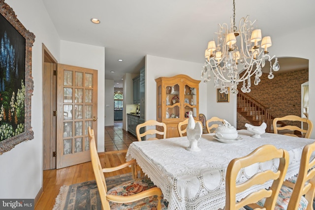 dining area with an inviting chandelier and light hardwood / wood-style flooring