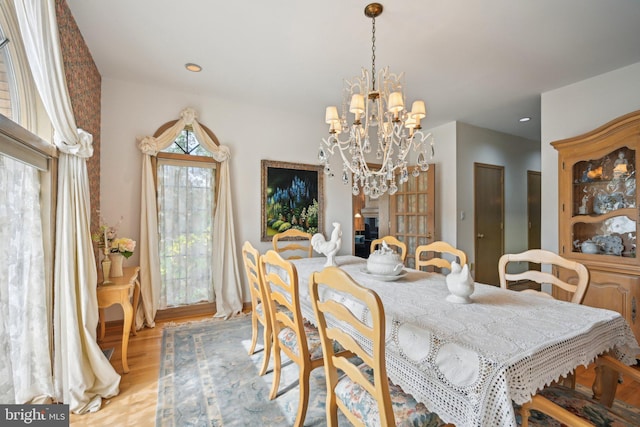 dining space featuring an inviting chandelier and light hardwood / wood-style flooring