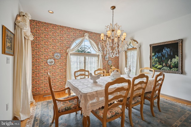 dining area with hardwood / wood-style flooring and a chandelier