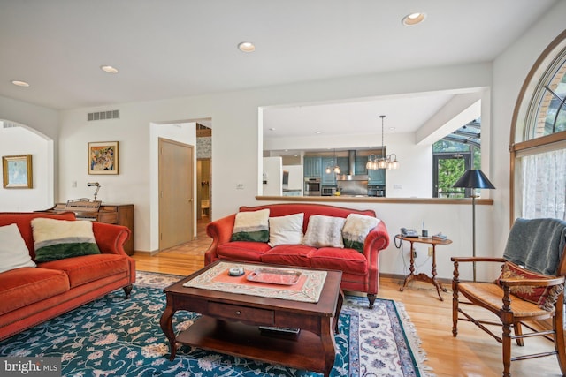 living room with an inviting chandelier and light hardwood / wood-style floors