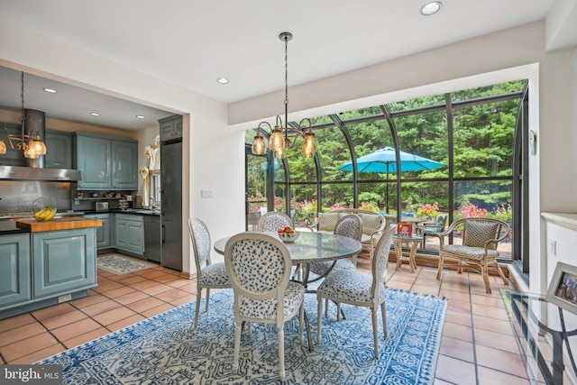 tiled dining room with a notable chandelier