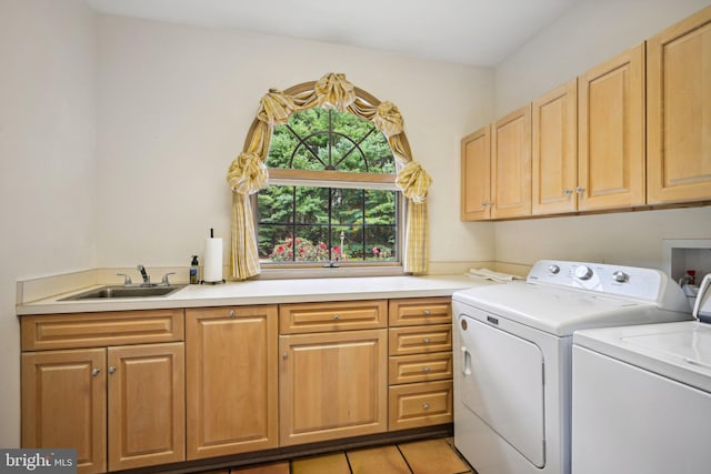 clothes washing area featuring light tile patterned floors, cabinets, sink, and washer and dryer