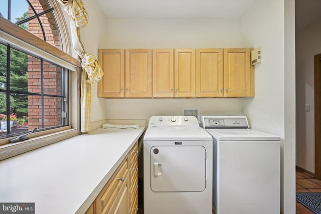 laundry area featuring cabinets, tile patterned floors, washing machine and dryer, and a wealth of natural light