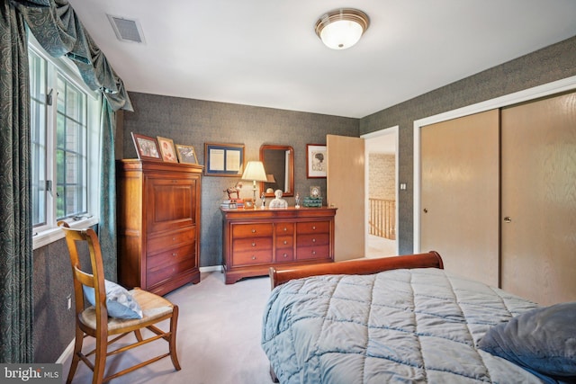 bedroom featuring light carpet and a closet