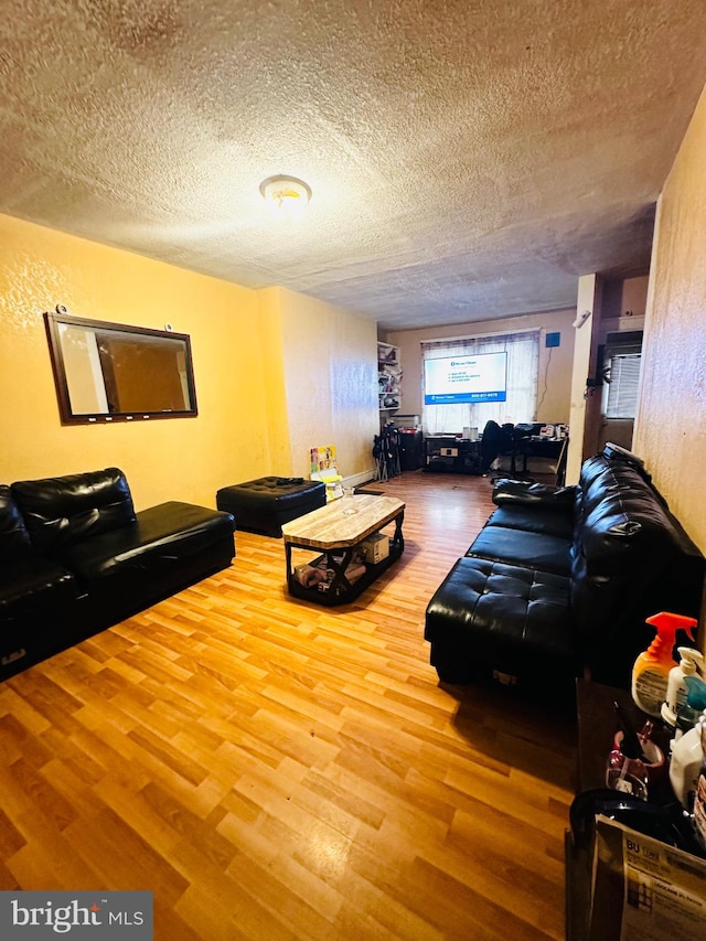 living room featuring a textured ceiling and wood-type flooring