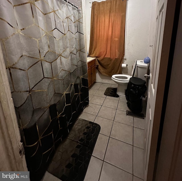 bathroom featuring vanity, toilet, walk in shower, and tile patterned flooring