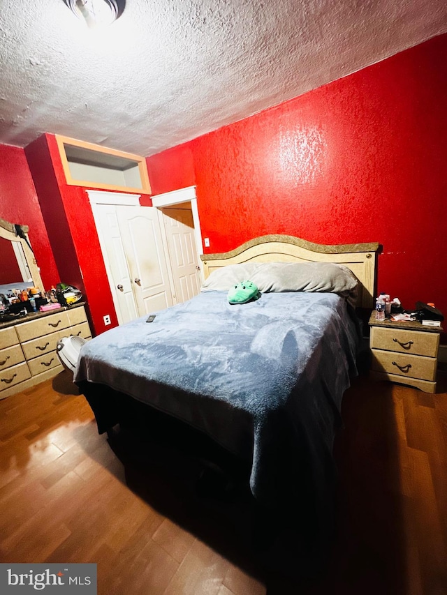 bedroom featuring dark wood-type flooring and a textured ceiling