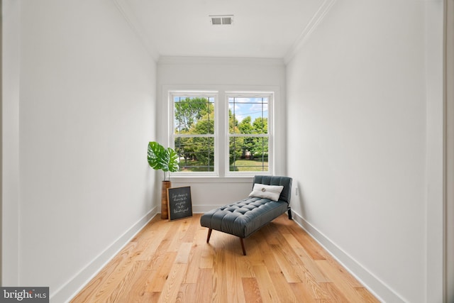 living area with ornamental molding and hardwood / wood-style flooring