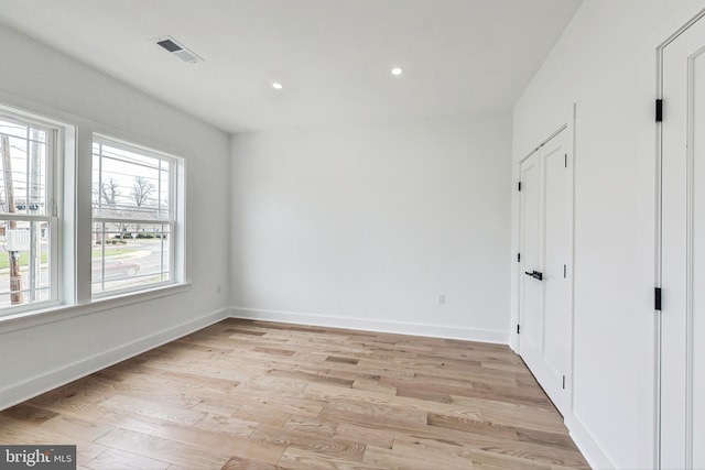 unfurnished bedroom featuring light wood-type flooring and multiple windows