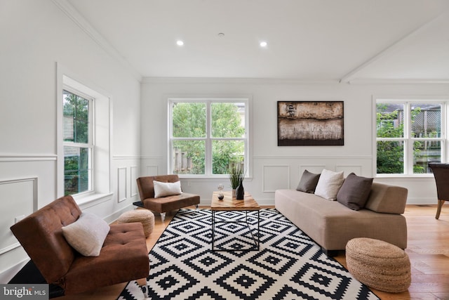 living room with hardwood / wood-style flooring, plenty of natural light, and ornamental molding