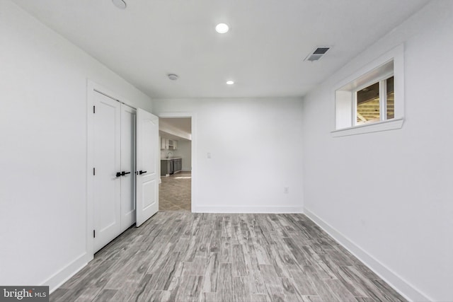 unfurnished bedroom with light hardwood / wood-style flooring and a closet