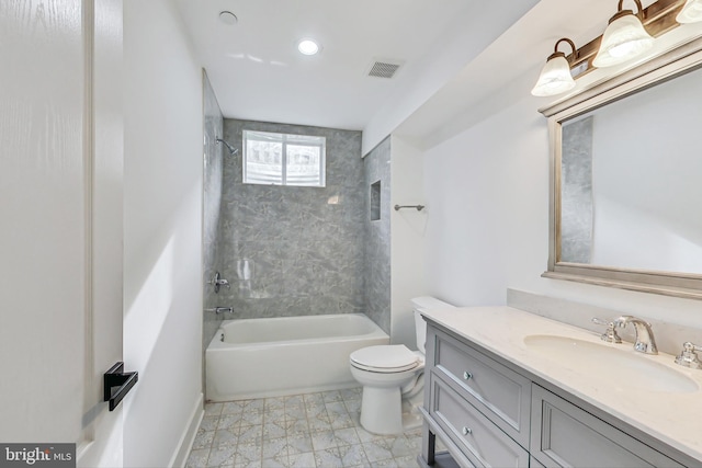 full bathroom with tiled shower / bath, vanity, and toilet