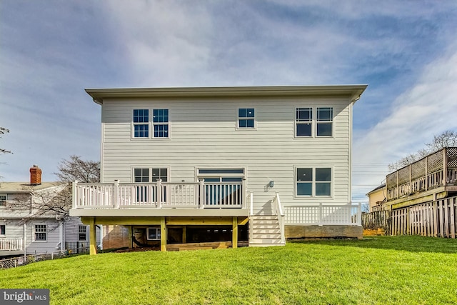 rear view of house with a deck and a yard