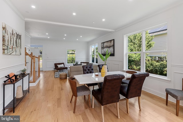 dining area with ornamental molding and light hardwood / wood-style floors