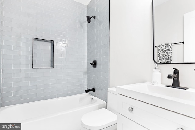 full bathroom featuring tiled shower / bath, toilet, and vanity