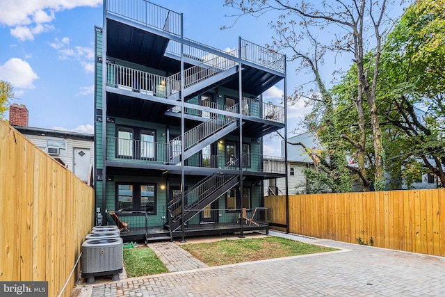 back of property featuring a balcony and central AC