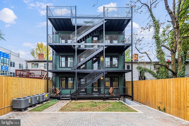 rear view of property with cooling unit and a balcony