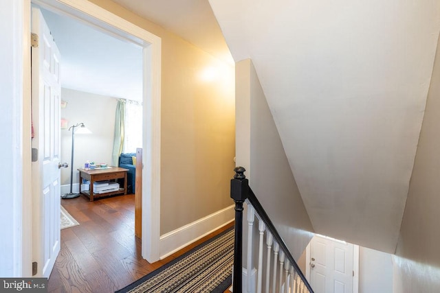 stairs featuring vaulted ceiling and hardwood / wood-style floors