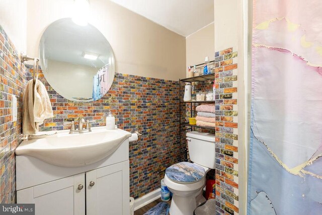 bathroom featuring tile walls, toilet, decorative backsplash, and vanity