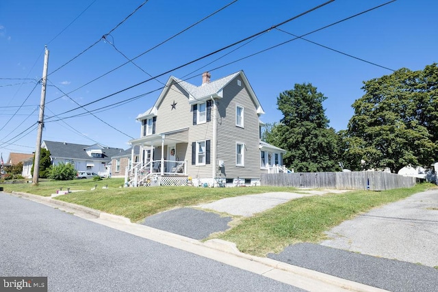 view of front of home with covered porch and a front yard