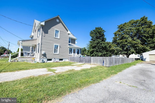 view of side of property featuring a yard and covered porch