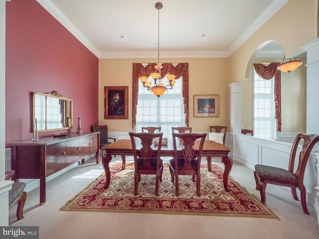 dining area with ornamental molding, light colored carpet, a healthy amount of sunlight, and a notable chandelier