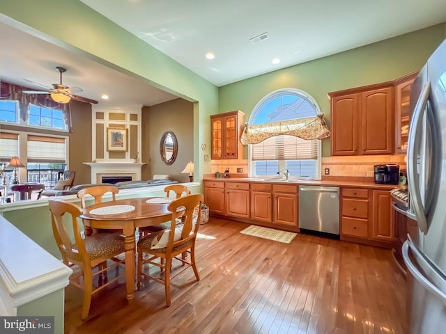 kitchen with hardwood / wood-style floors, sink, ceiling fan, tasteful backsplash, and stainless steel appliances