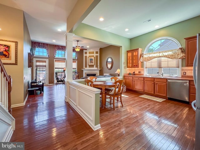 kitchen with backsplash, ceiling fan, dark hardwood / wood-style flooring, and stainless steel appliances