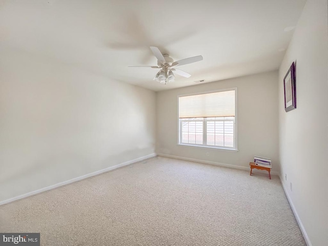 carpeted spare room with ceiling fan