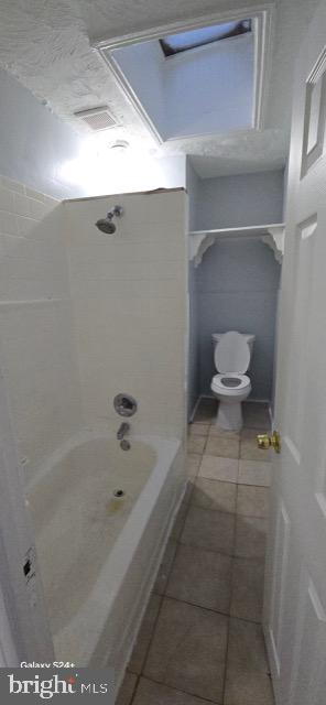 bathroom featuring toilet, shower / bath combination, and tile patterned floors