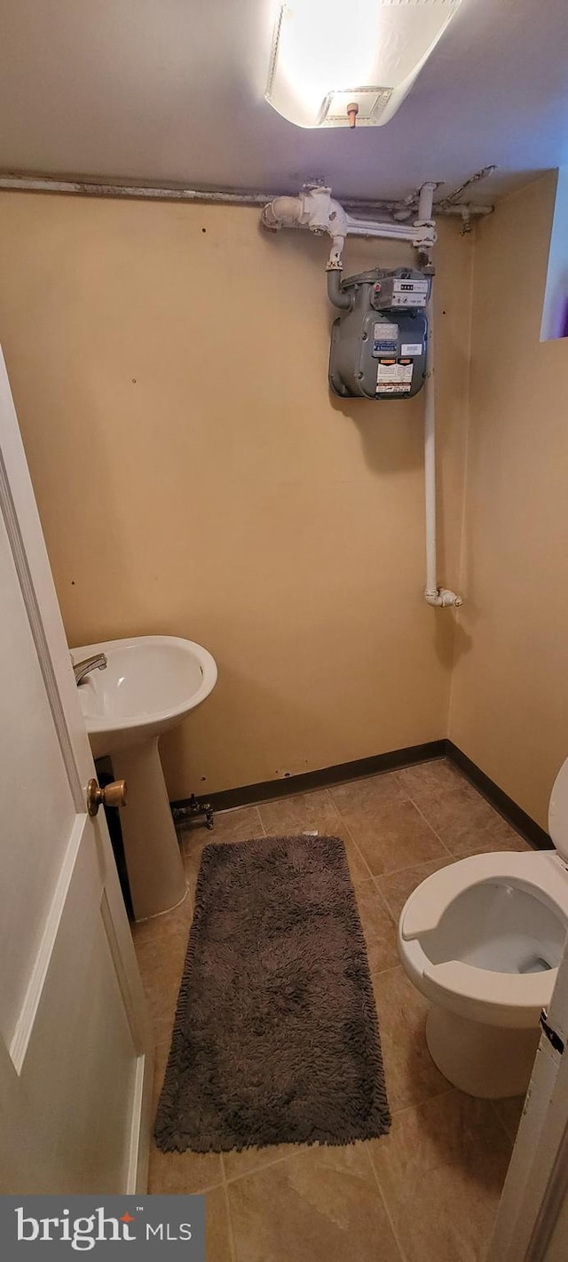 bathroom with toilet and tile patterned floors