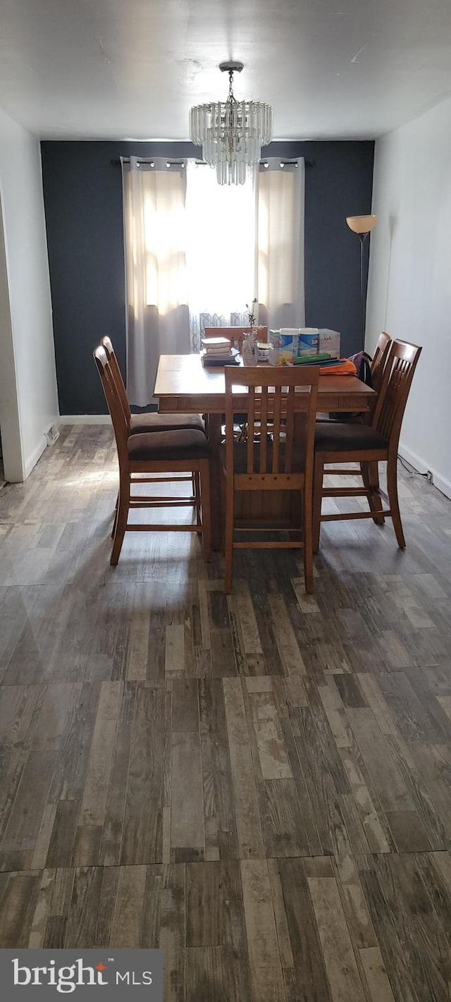 dining room featuring dark hardwood / wood-style flooring and an inviting chandelier