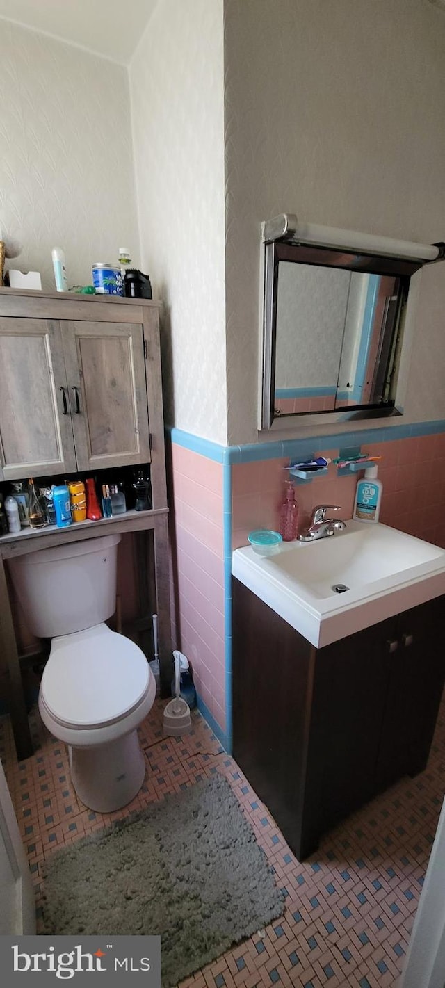 bathroom featuring tile walls, toilet, decorative backsplash, and vanity