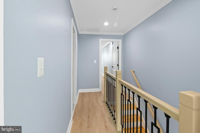 corridor featuring light wood-type flooring and crown molding